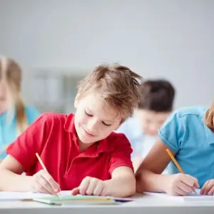 two kids writing with pencils in a notebook