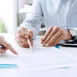 closeup of a pencil in hand pointing to a document