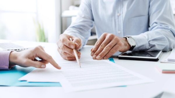 closeup of a pencil in hand pointing to a document