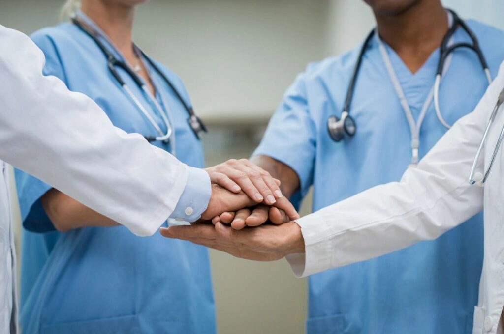 doctors are making a promise by placing their hands over each other's hands