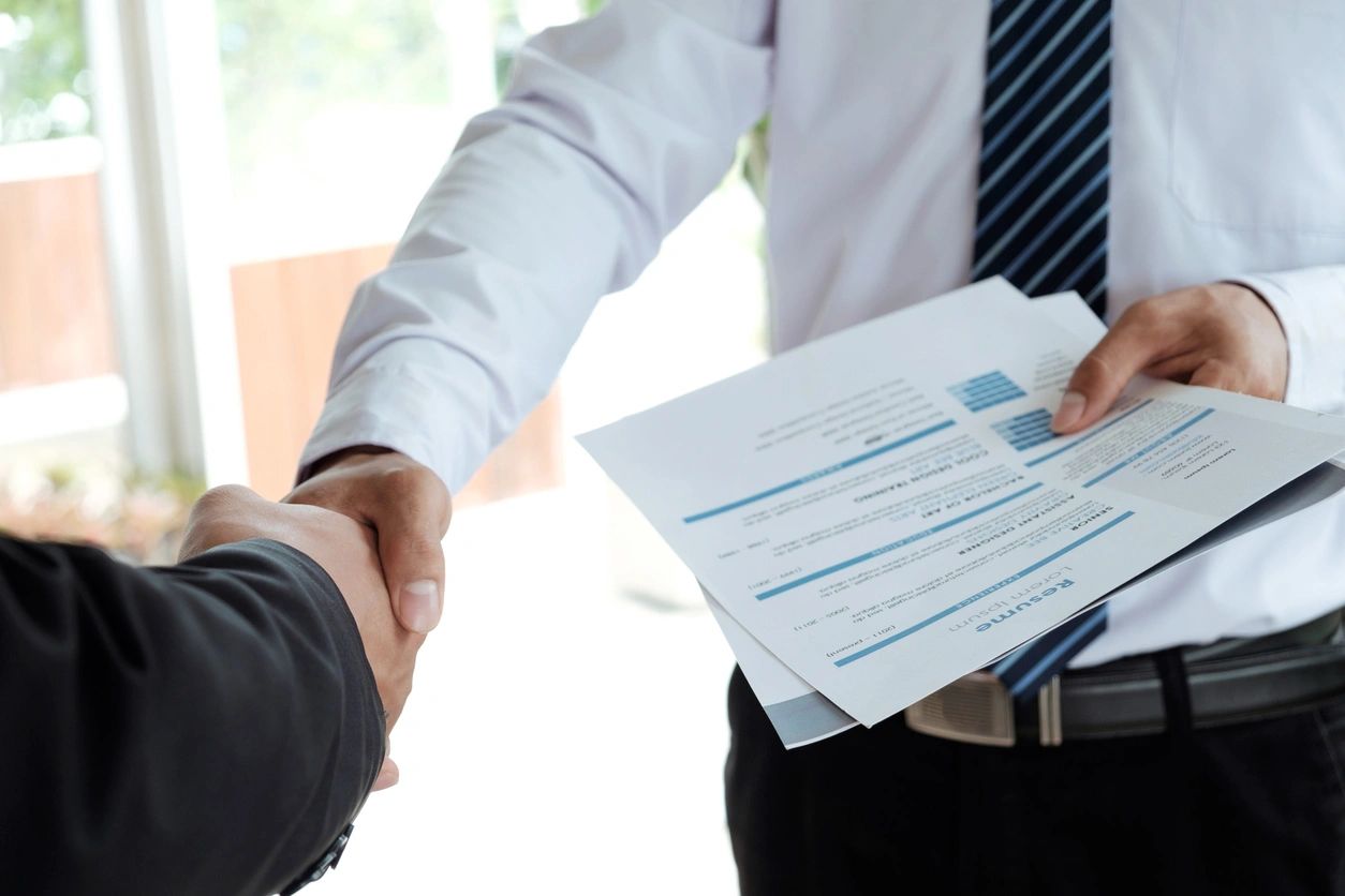 closeup shot of hand shaking and documents