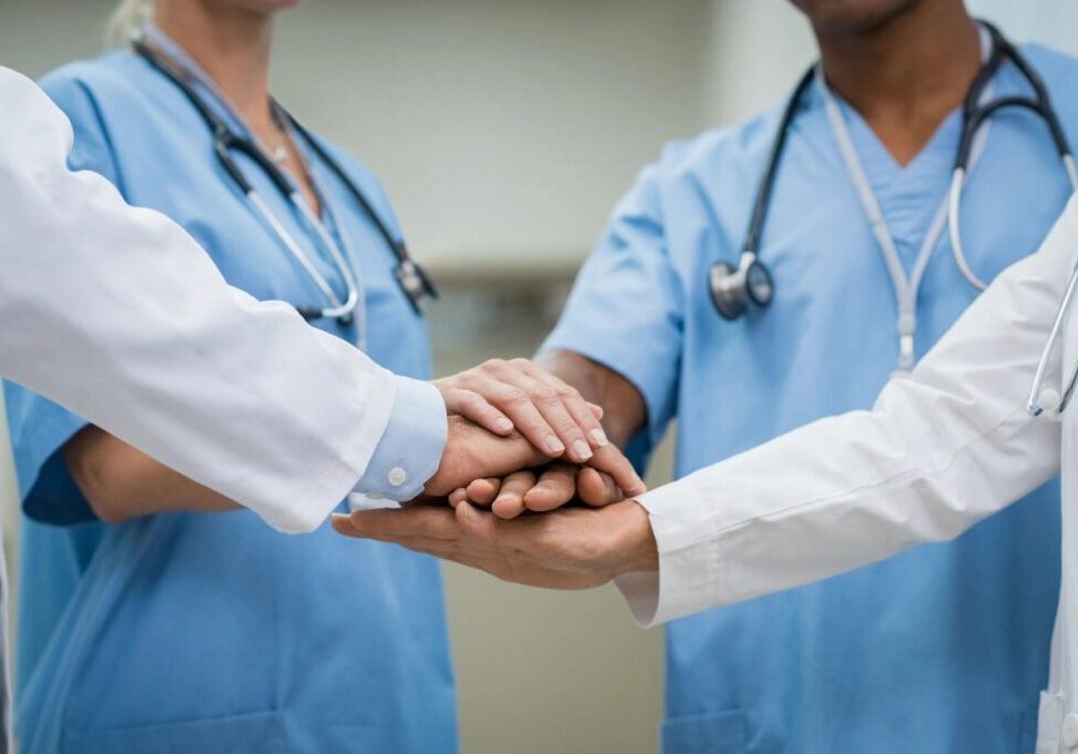 doctors are making a promise by placing their hands over each other's hands